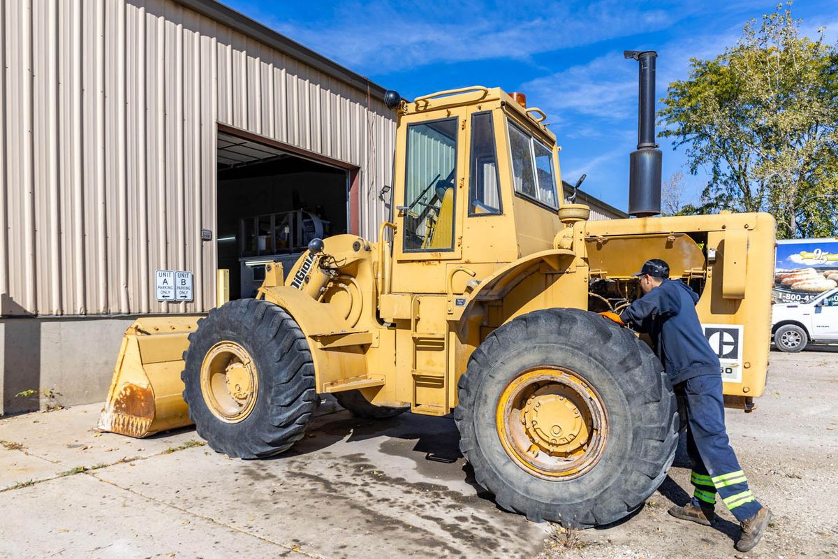 Big Rig Fixer technician working on a yellow wheel loader